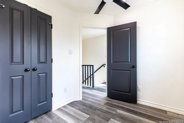 a view of a hallway with wooden floor and staircase