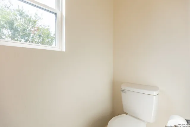 a white toilet sitting next to a window