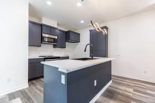 a kitchen with a sink a stove and cabinets