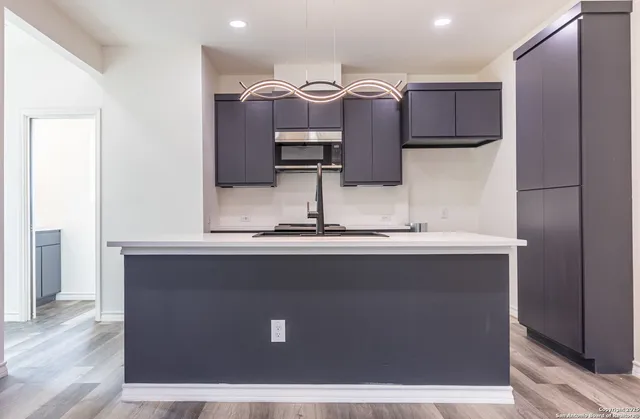 a view of kitchen with stainless steel appliances granite countertop a refrigerator and a sink