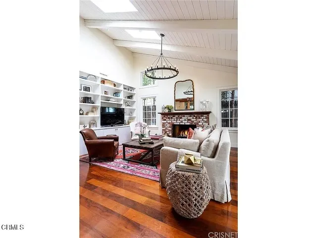 a living room with furniture a fireplace and a flat screen tv