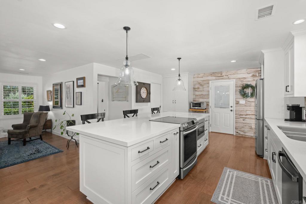 1848 Tavern Road Alpine, CA 91901 - Photo 9 of 45 a large kitchen with kitchen island a stove a sink a center island and couches