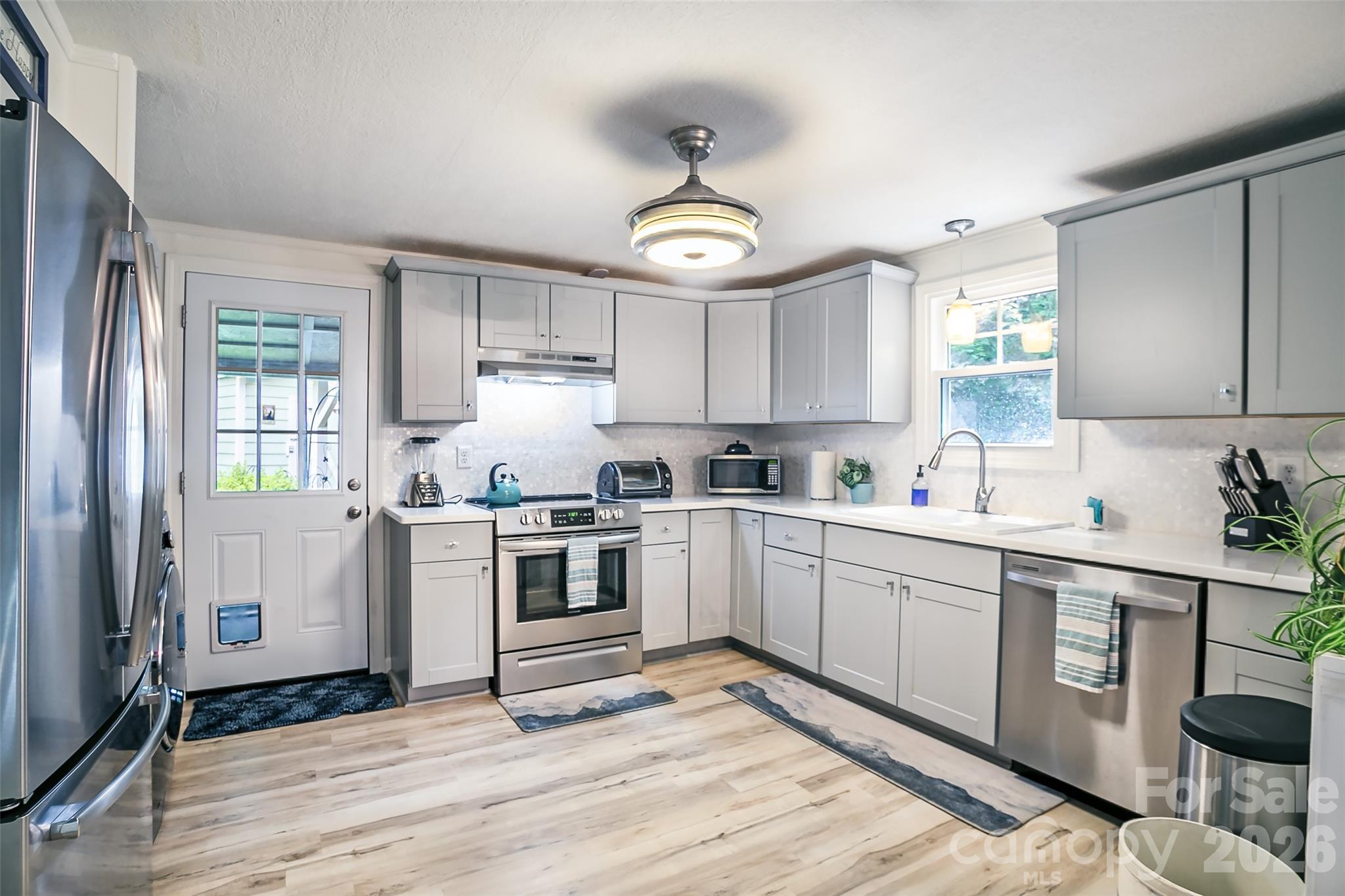 74 Huntley Road Fletcher, NC 28732 - Photo 4 of 45 a kitchen with granite countertop a stove a sink and a refrigerator