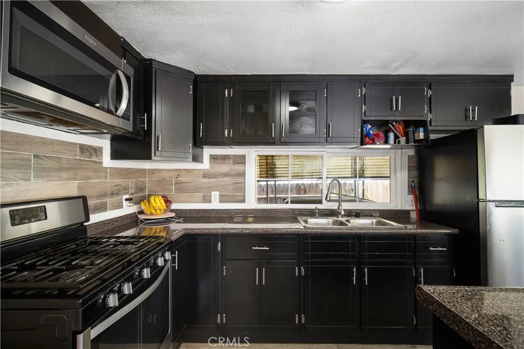 348 Petrol Road Bakersfield, CA 93308 - Photo 12 of 21 a kitchen with stainless steel appliances a sink a stove and a microwave