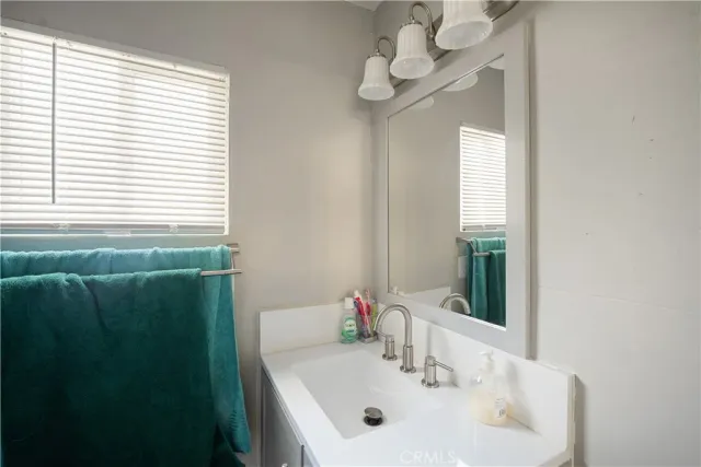 a bathroom with a sink a mirror and a window