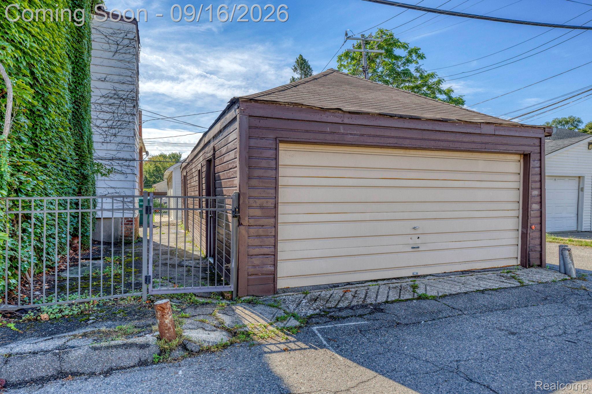999 Nottingham Road Grosse Pointe, MI 48230 - Photo 30 of 30 Detached garage with horizontal siding, a roll-up door, and a security gate