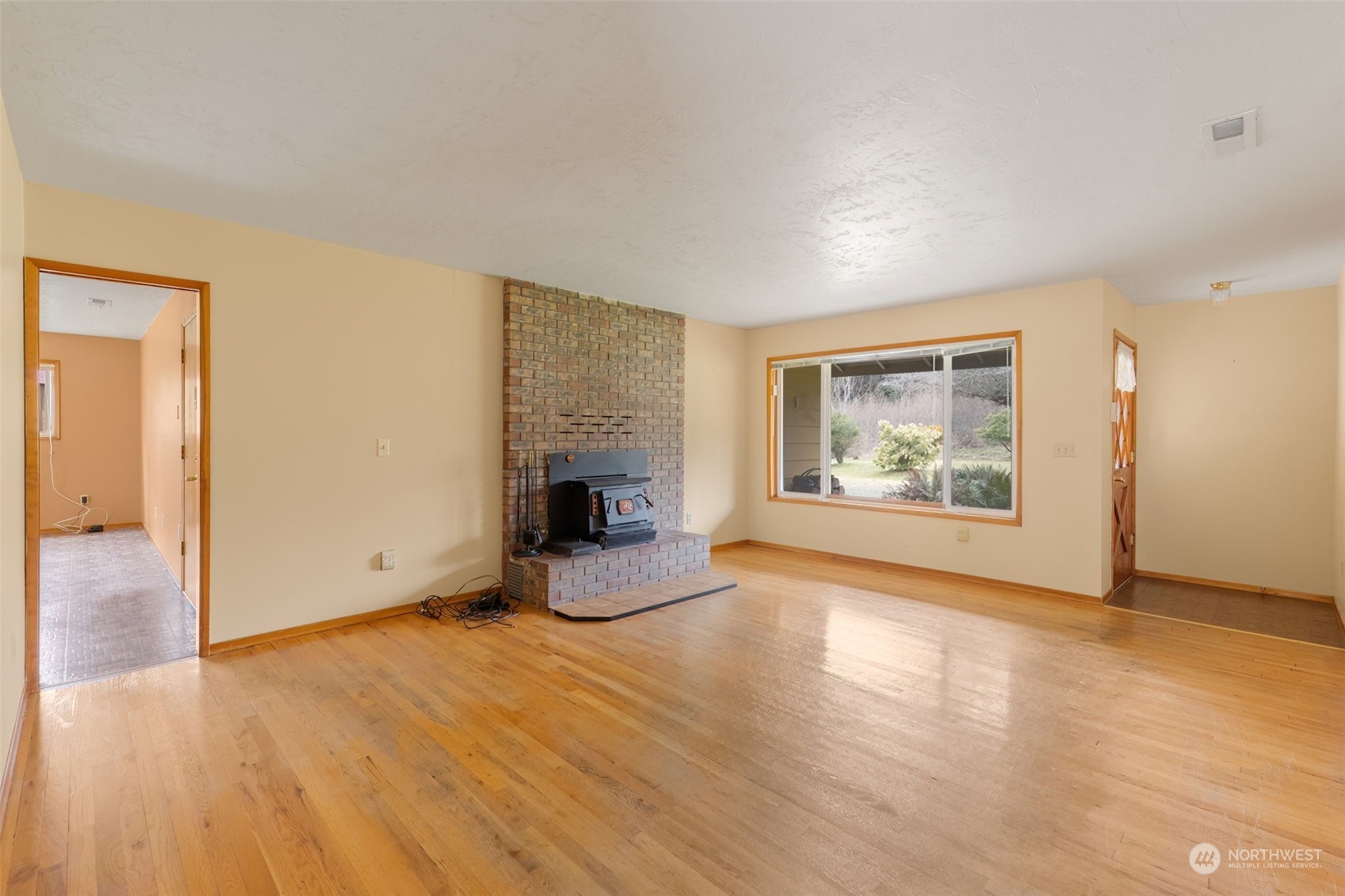 521 Robertson Road Longview, WA 98632 - Photo 5 of 40 an empty room with wooden floor and fireplace