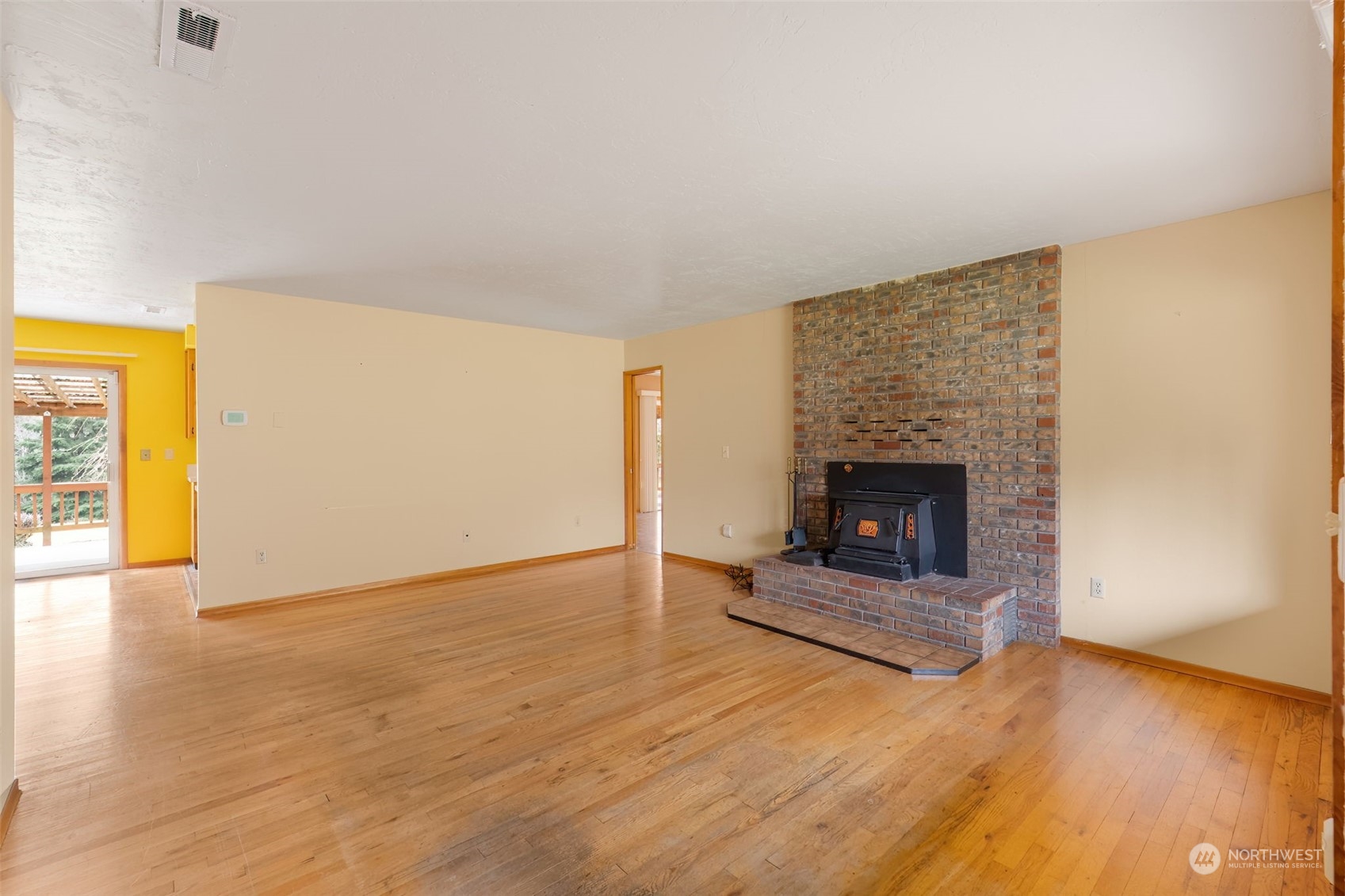 521 Robertson Road Longview, WA 98632 - Photo 6 of 40 a view of an empty room with wooden floor fireplace and a window