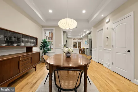 a kitchen with stainless steel appliances granite countertop a table chairs and a refrigerator