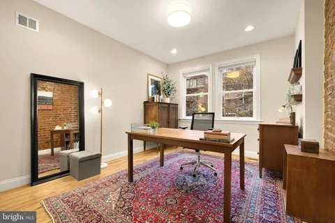 a living room with furniture and paintings on the wall