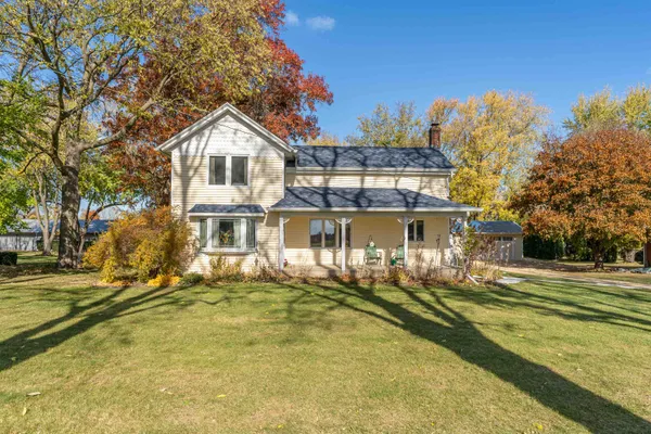 a front view of a house with a yard and trees