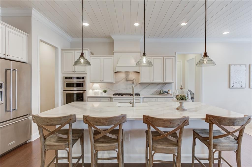632 Rio Vista Court Suwanee, GA 30024 - Photo 15 of 64 a kitchen with kitchen island a stove a table and chairs in it