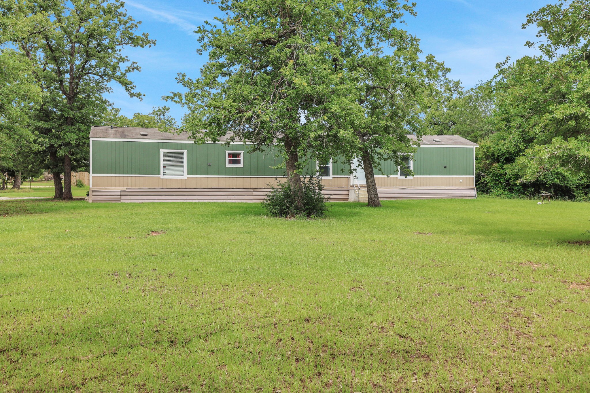 a view of a house with a yard and tree