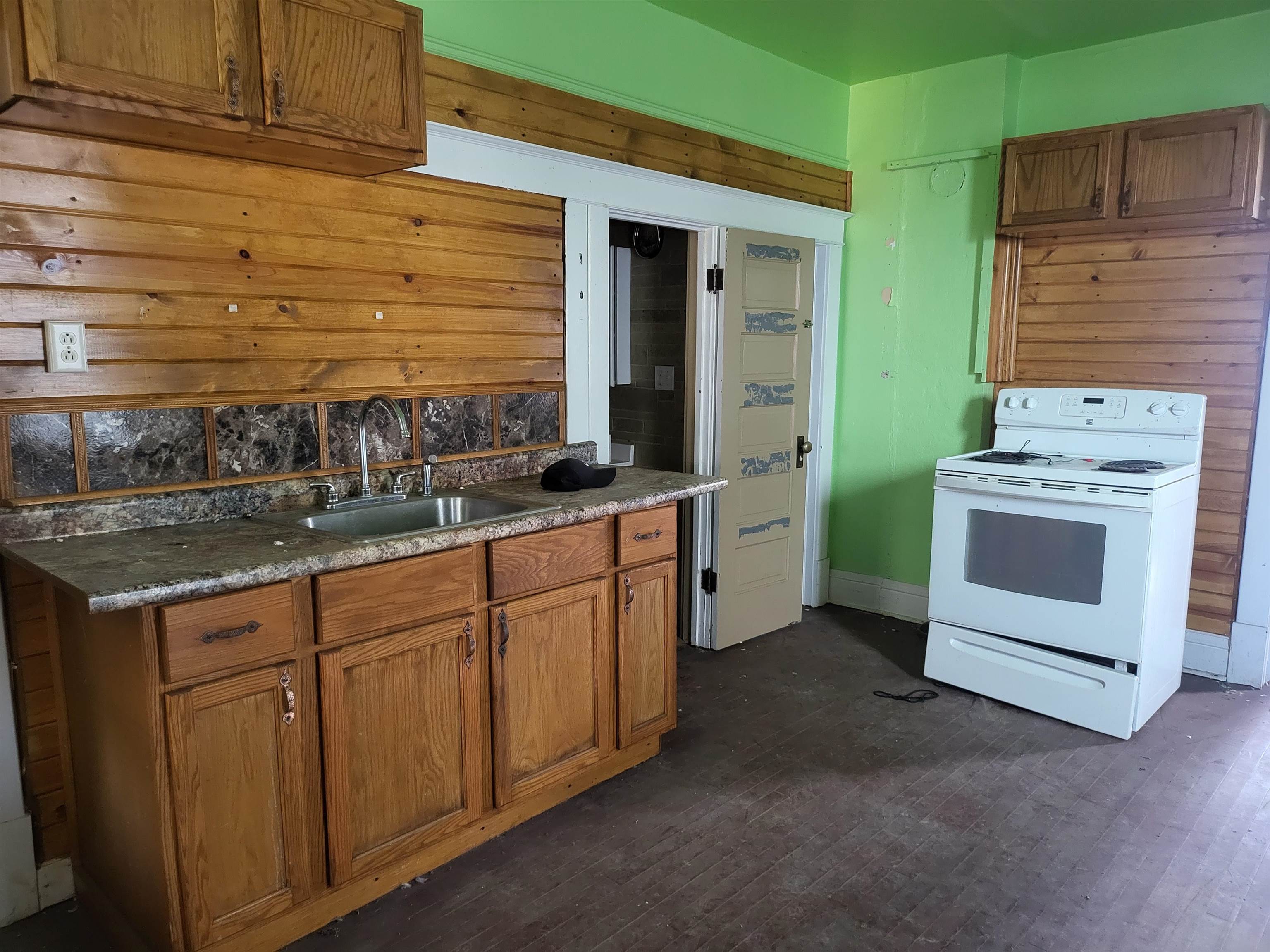 119 8th Street South Virginia, MN 55792 - Photo 4 of 18 Kitchen with white electric range, brown cabinets, dark wood-style flooring, and dark countertops