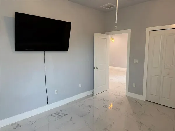 a view of an empty room with wooden floor and cabinet