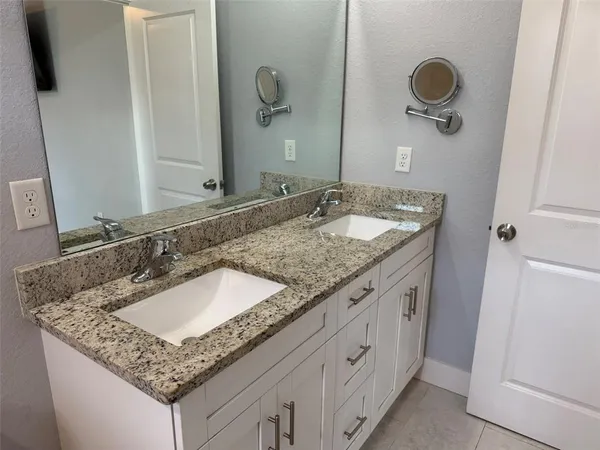 a bathroom with a granite countertop sink and a mirror