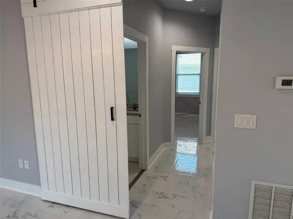 a view of a hallway with wooden shelves