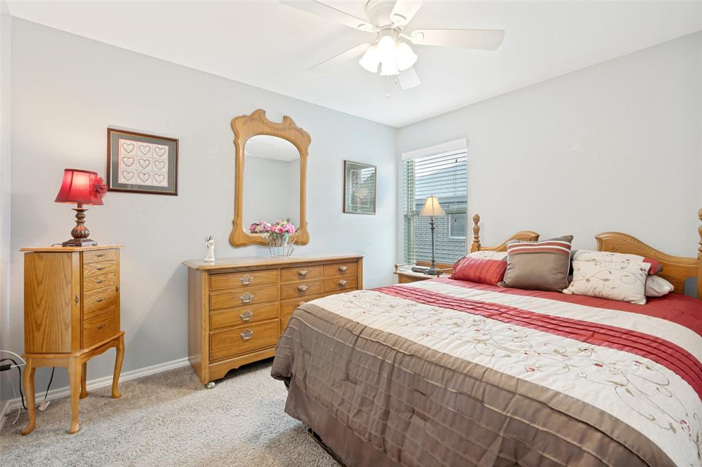 3905 Bridle Path Lane Sanger, TX 76266 - Photo 18 of 26 a bedroom with a bed and a chandelier