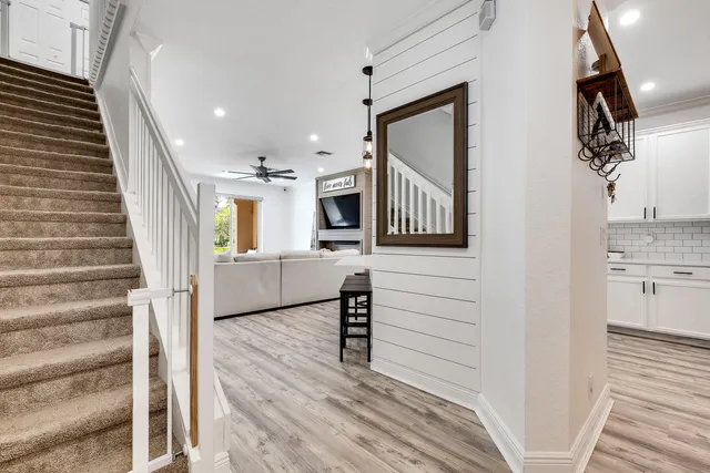 a view of a hallway with wooden floor and staircase