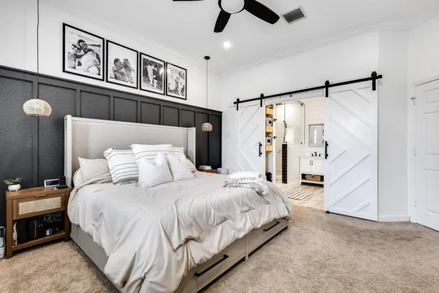 a bedroom with a large bed and a chandelier