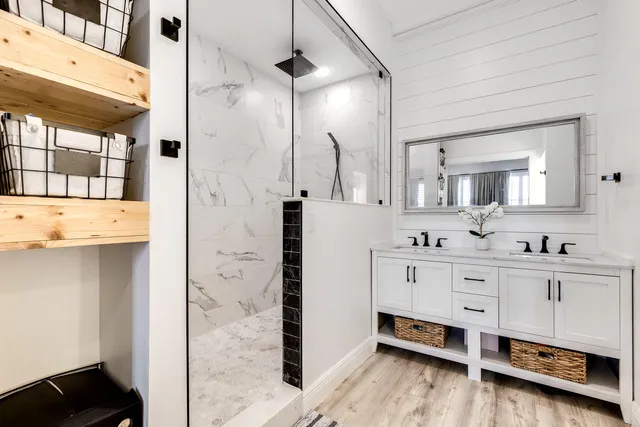 a spacious bathroom with a double vanity sink a mirror and a shower