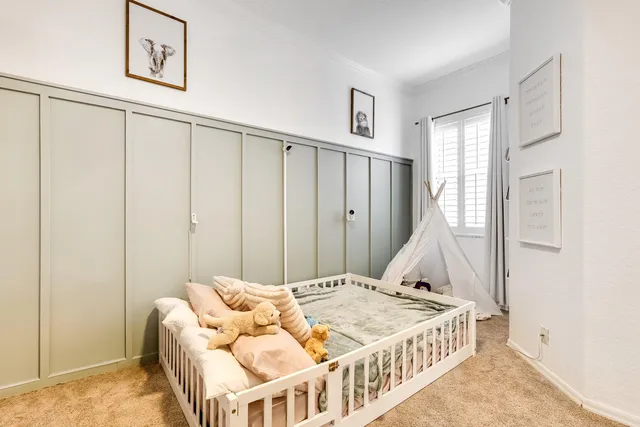 a bed sitting in a bedroom next to a window