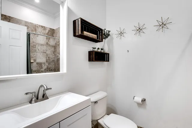 a bathroom with a toilet a sink and mirror