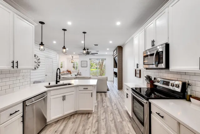 a kitchen with stainless steel appliances a sink stove and cabinets
