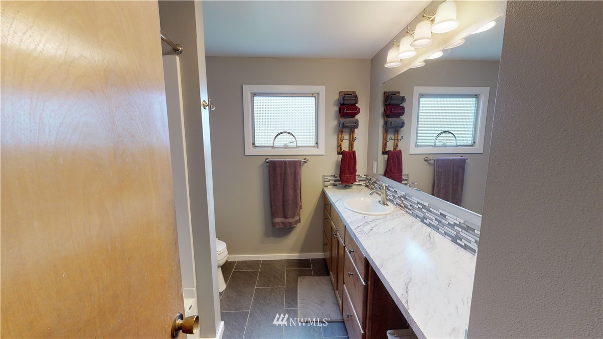 17307 Dunbar Road Mount Vernon, WA 98273 - Photo 10 of 22 a bathroom with a sink a mirror and a toilet