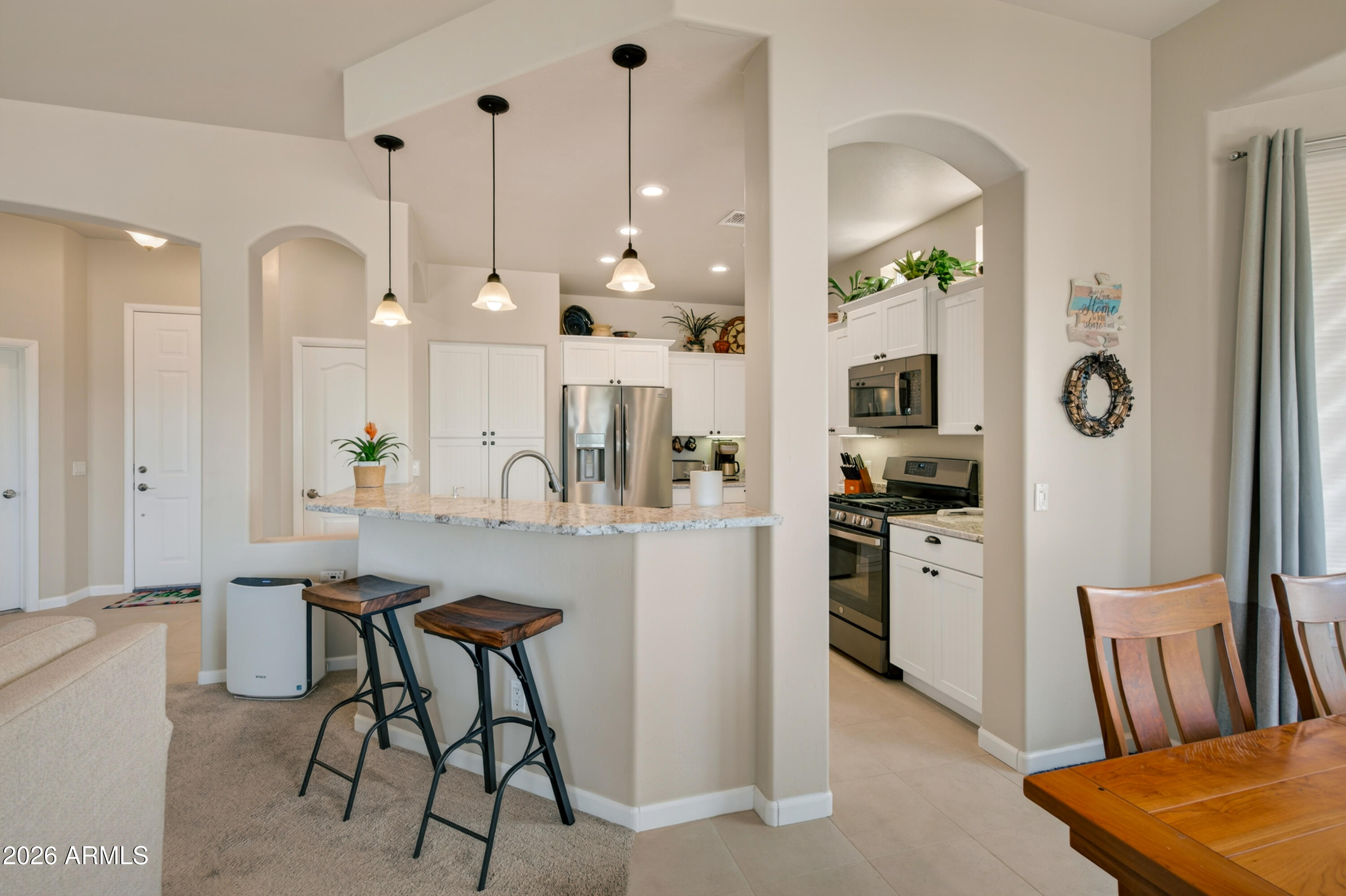 718 South Wandering River Road Cornville, AZ 86325 - Photo 12 of 41 a kitchen with stainless steel appliances kitchen island a refrigerator a sink a stove and chairs