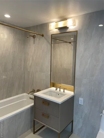 a bathroom with a sink mirror and a bathtub
