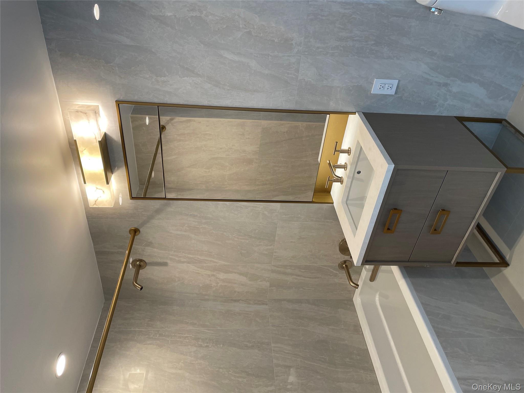 3 Court Square, Unit 5211 Queens, NY 11101 - Photo 10 of 13 a bathroom with a sink mirror and a bathtub