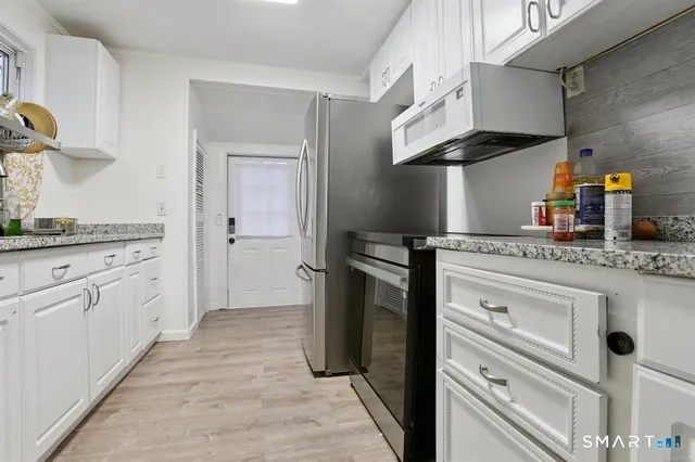 a kitchen with stainless steel appliances granite countertop a sink and a stove