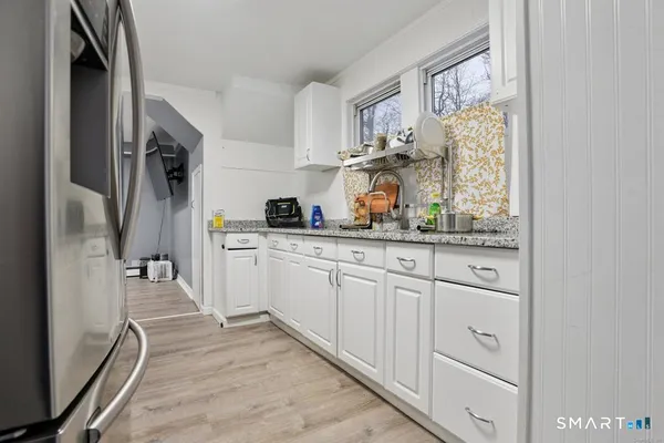 a kitchen with white cabinets and window