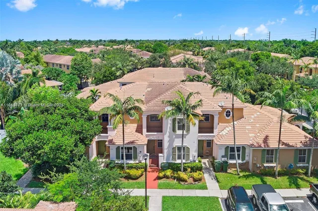 an aerial view of multiple houses with a yard