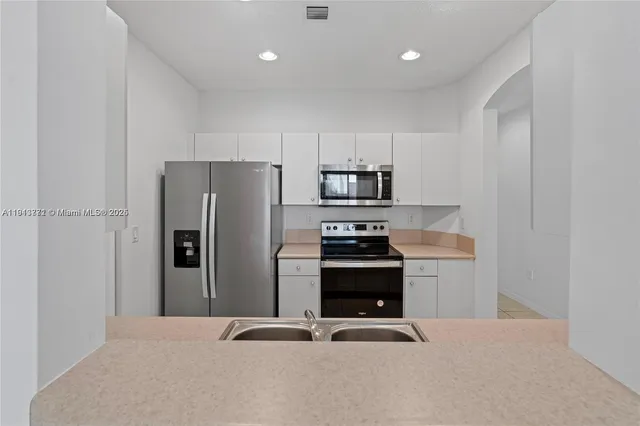 a kitchen with white cabinets and stainless steel appliances