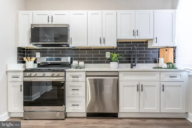 a kitchen with stainless steel appliances granite countertop a stove a microwave and cabinets