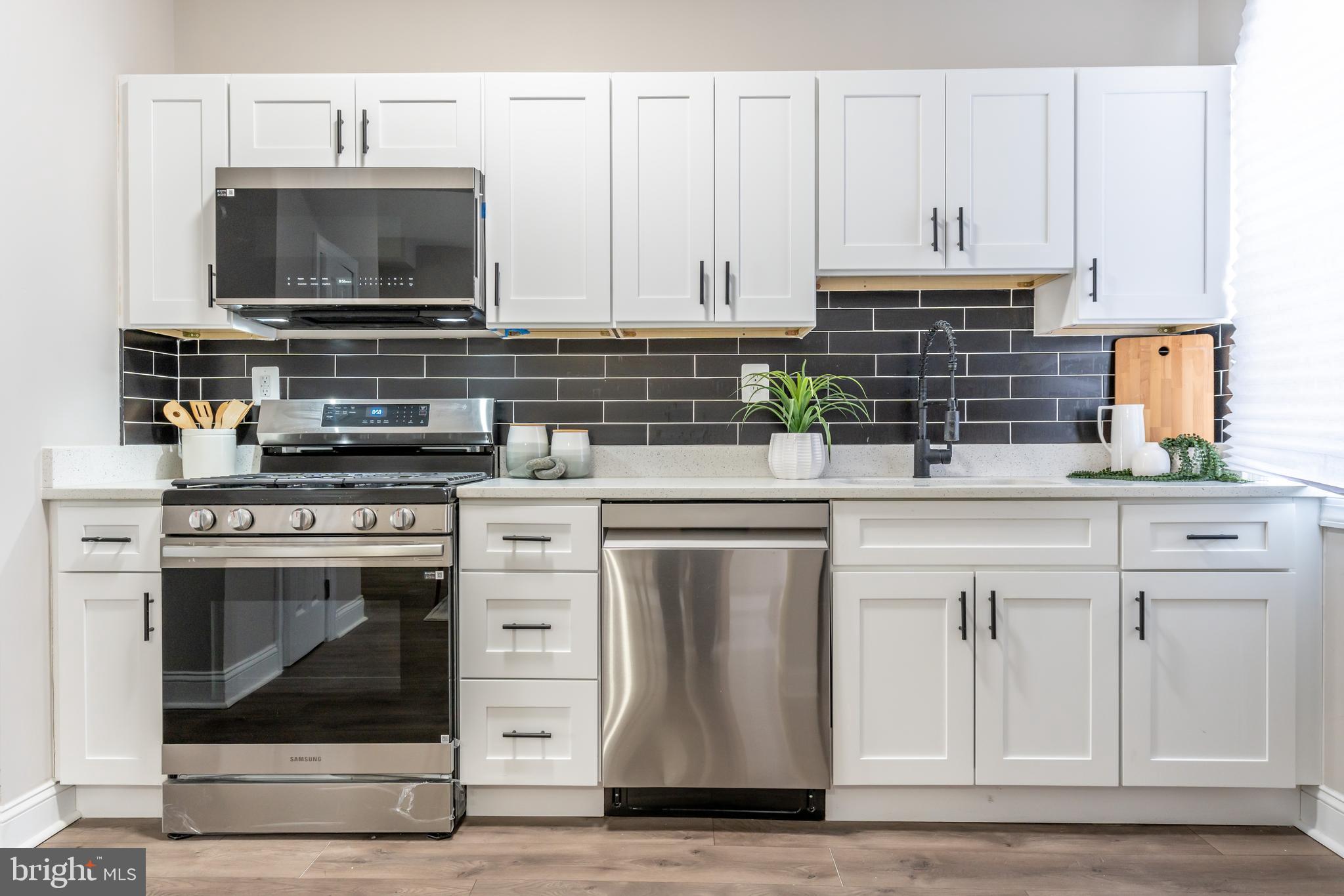 3651 Cottage Avenue Baltimore, MD 21215 - Photo 14 of 38 a kitchen with stainless steel appliances granite countertop a stove a microwave and cabinets