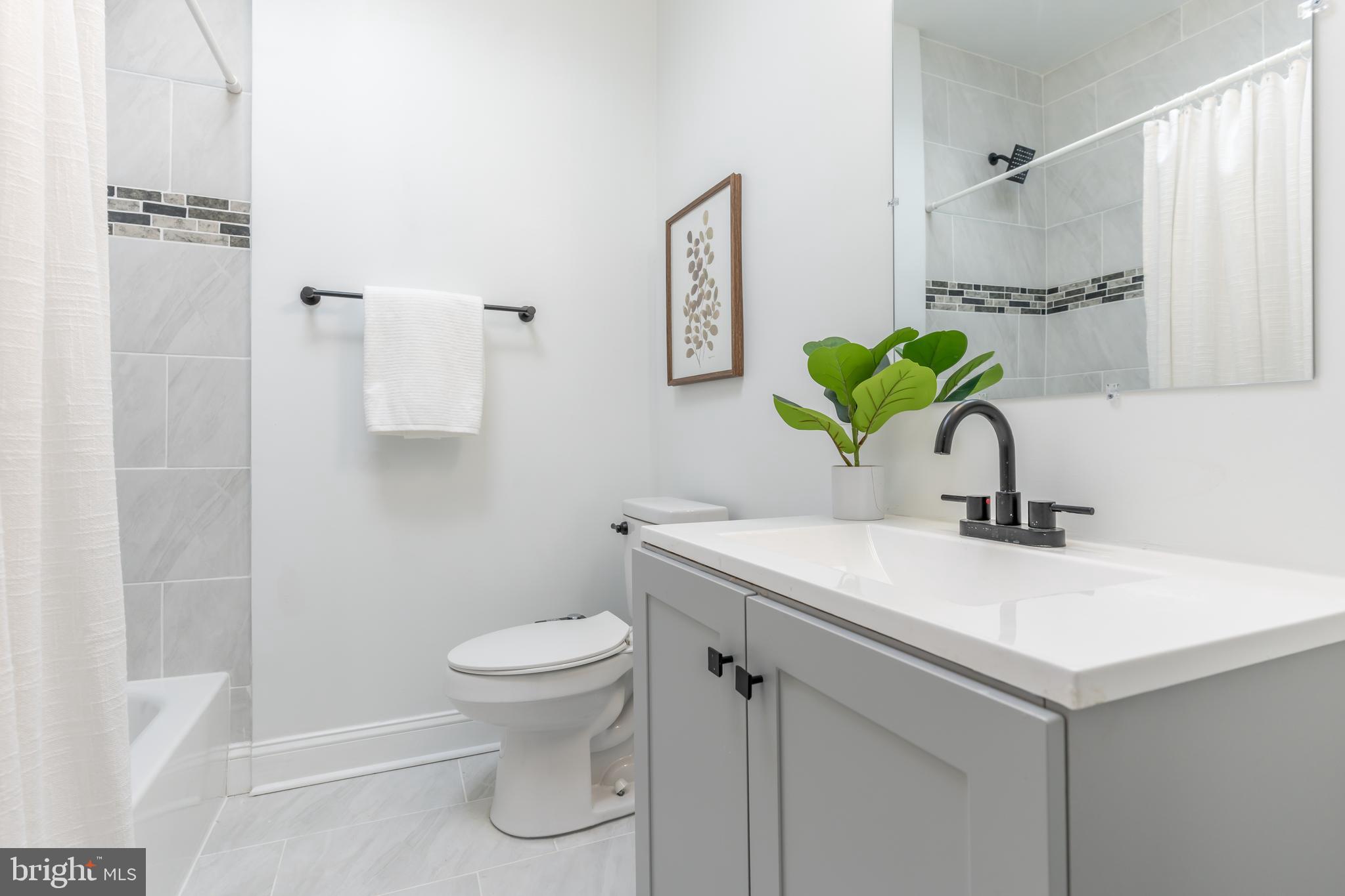 3651 Cottage Avenue Baltimore, MD 21215 - Photo 21 of 38 a bathroom with a sink a toilet and a mirror