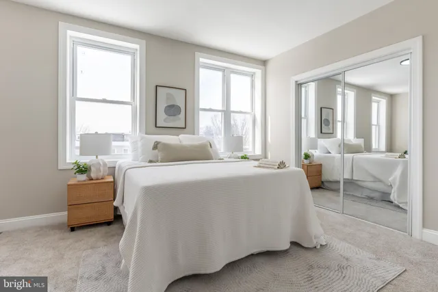 a bedroom with a bed and a large window