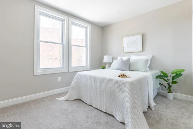 a bedroom with a bed and a potted plant