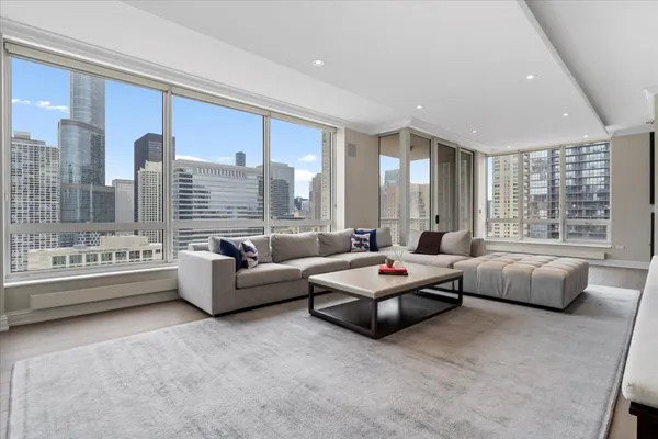 a large white kitchen with stainless steel appliances granite countertop a stove and a sink