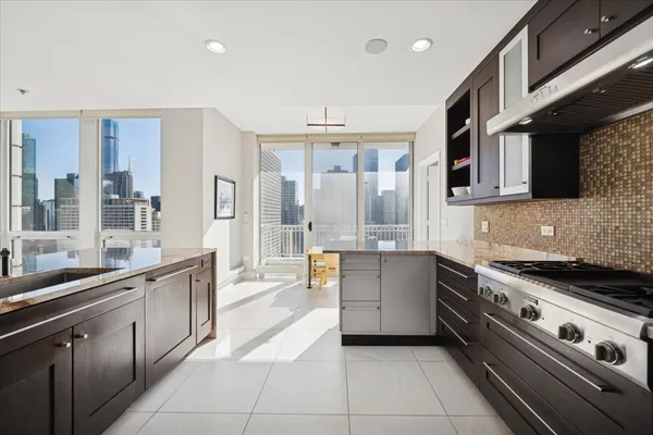 a kitchen with stainless steel appliances kitchen island granite countertop a refrigerator and a stove top oven