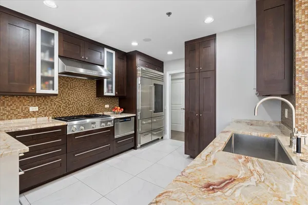a large white kitchen with glass top table and chairs