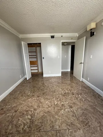 an empty room with closet and mirror