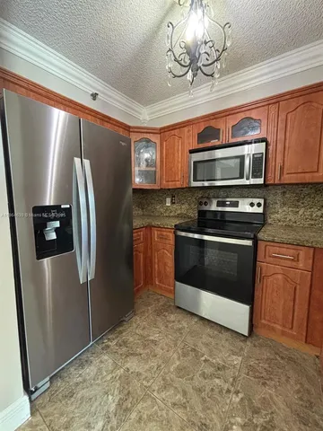 a kitchen with stainless steel appliances granite countertop a refrigerator a stove a sink and dishwasher