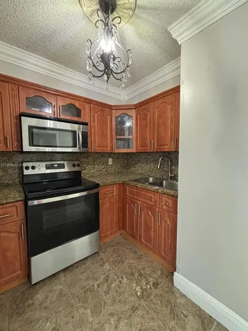 a kitchen with stainless steel appliances granite countertop a stove and a microwave