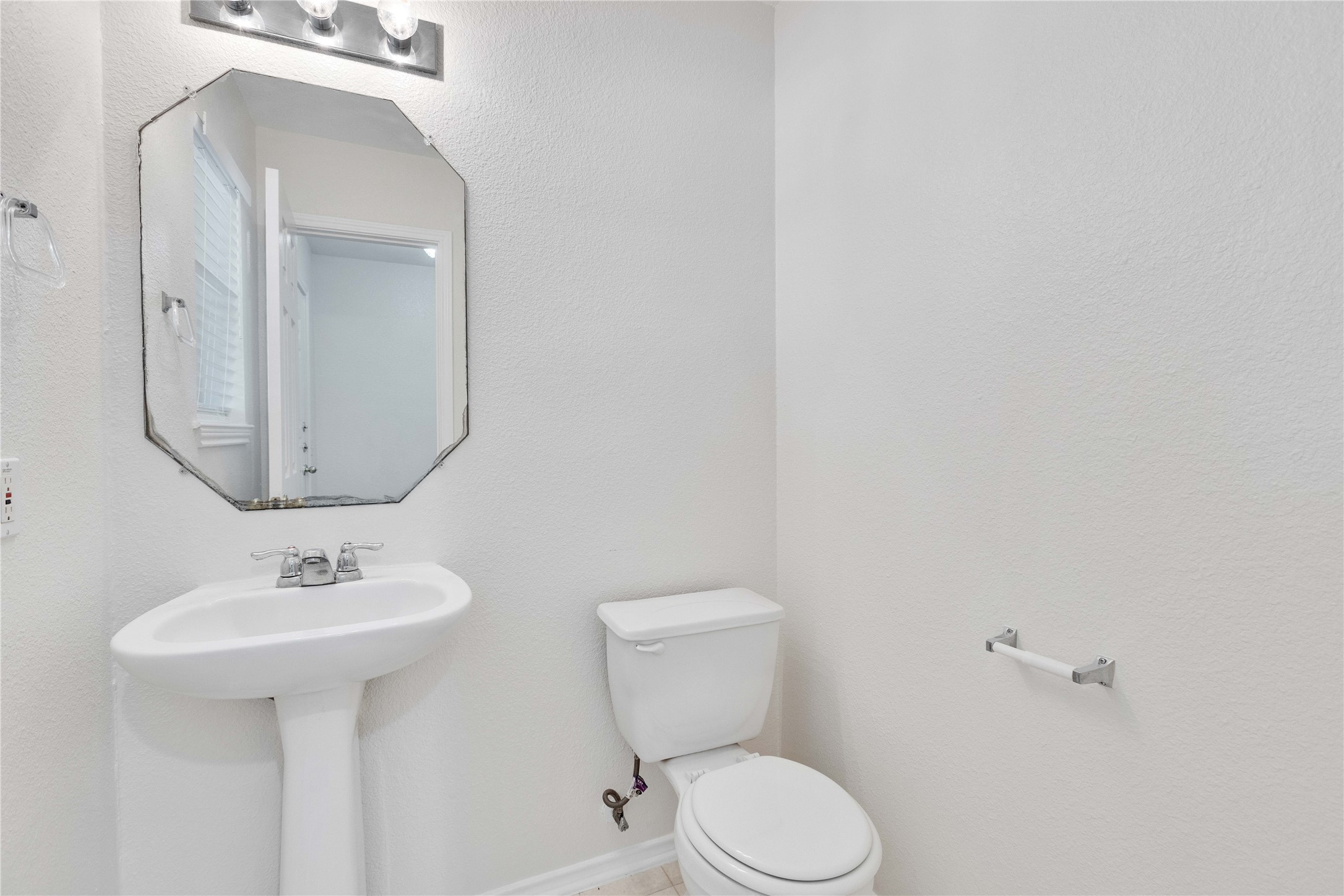14418 Pebble Run Path Manor, TX 78653 - Photo 3 of 27 A well-appointed half bath features a pedestal sink and simple, clean design.