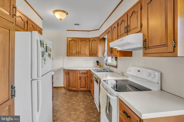 a kitchen with a sink a refrigerator and a stove