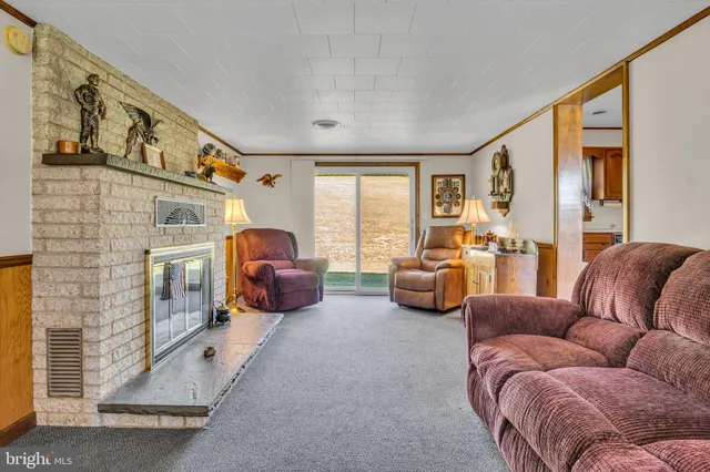 a living room with furniture ceiling fan and a large window